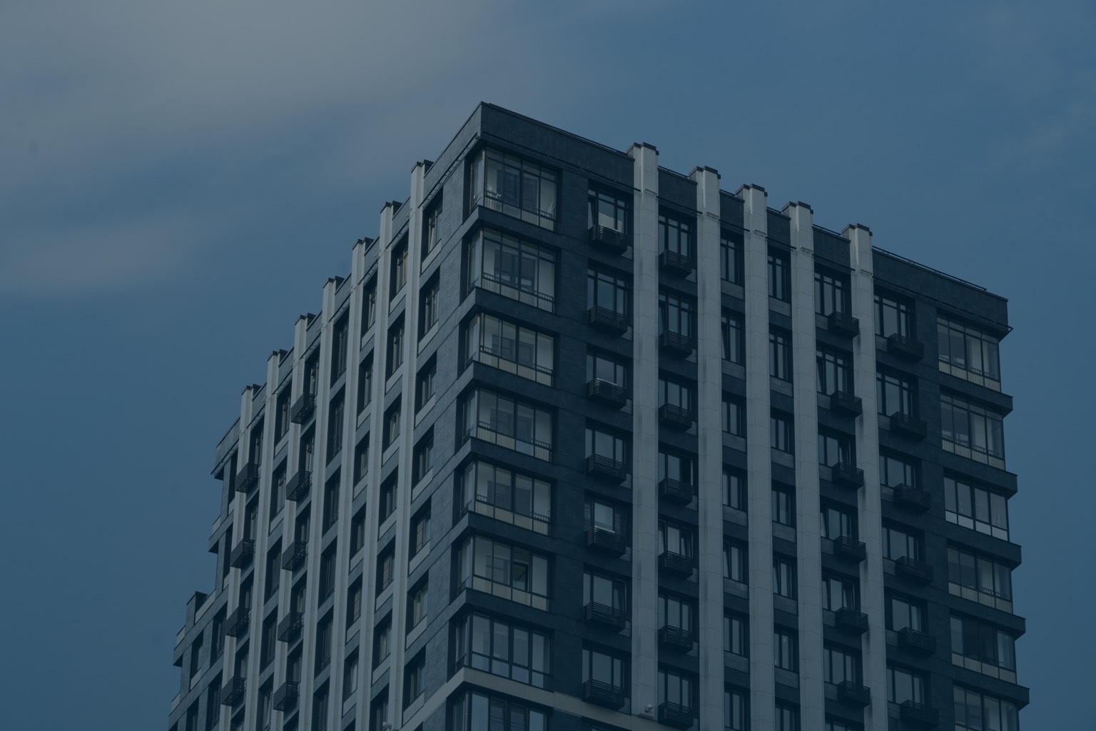 Residential apartment tower against a cloudy sky